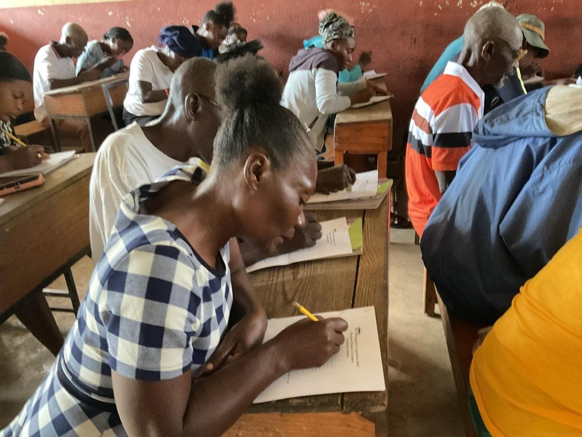 A woman writing in a notebook during an adult literacy class.